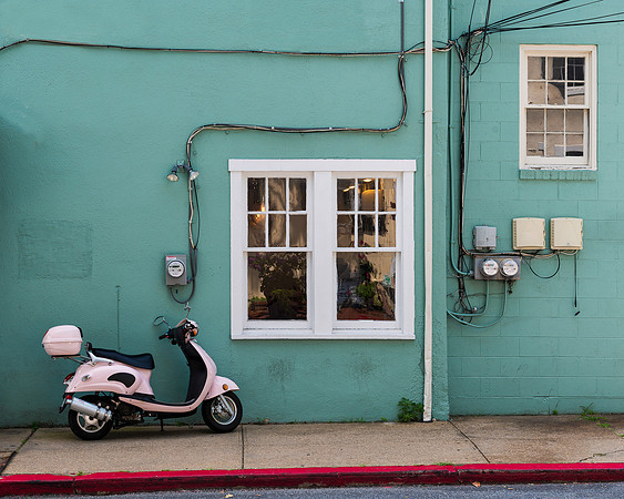 Pink scooter against green wall