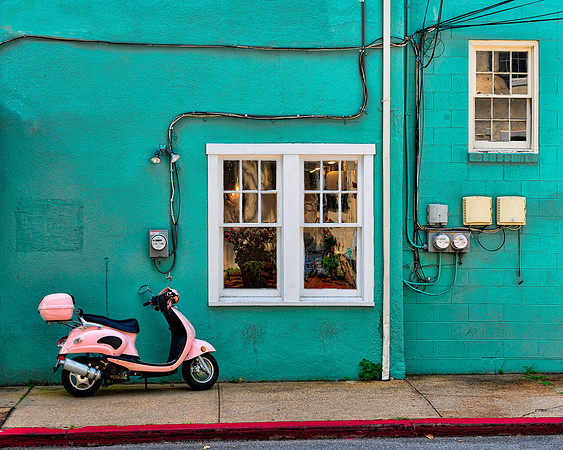Pink scooter against green wall