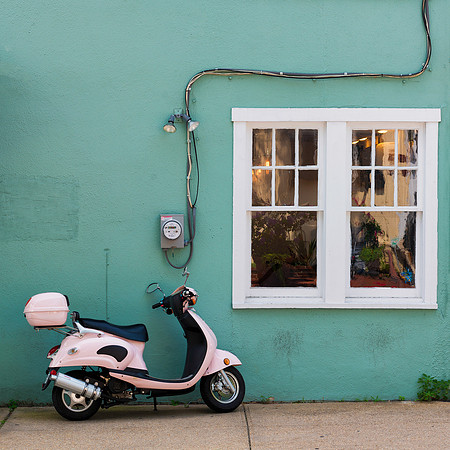 Pink scooter against green wall