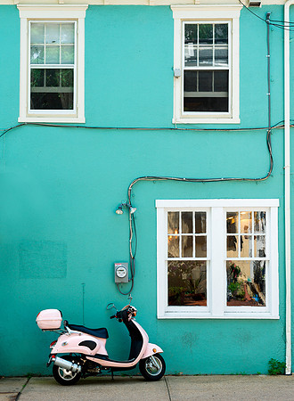 Pink scooter against green wall