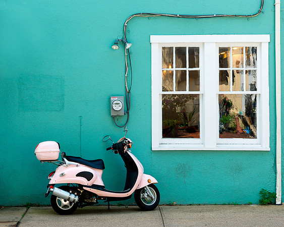Pink scooter against green wall